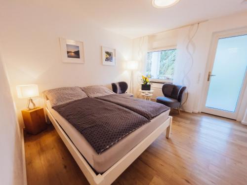 ein Schlafzimmer mit einem Bett, einem Stuhl und einem Fenster in der Unterkunft Ferienwohnung Mosel in Bernkastel-Kues