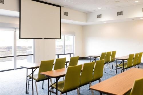 a conference room with tables and chairs and a large screen at Holiday Inn Express & Suites Lexington North West-The Vineyard by IHG in Lexington
