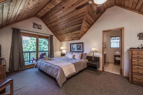 - une chambre avec un grand lit et un plafond en bois dans l'établissement Breakaway Cabin, 3 Bedrooms, Sleeps 6, Pets Welcome, Wood Fireplace, à Ruidoso