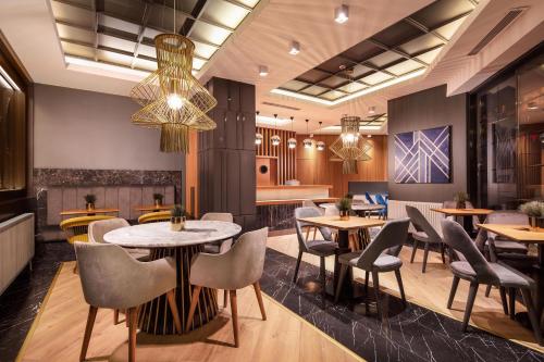 a restaurant with tables and chairs and a chandelier at B LOFT HOTEL in Bursa