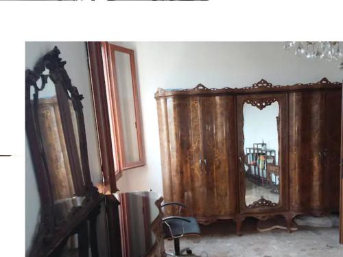 マルゲーラにあるSpacious roomの木製のキャビネットと鏡が備わる客室です。