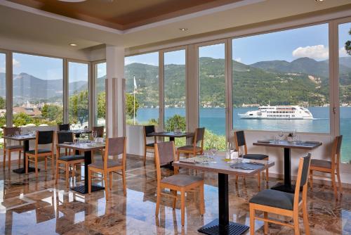 a restaurant with tables and chairs with a cruise ship in the background at Park Hotel Casimiro in San Felice del Benaco