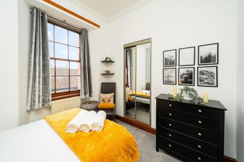 um quarto com uma cama, uma cómoda e uma janela em The Tollbooth em Clackmannan