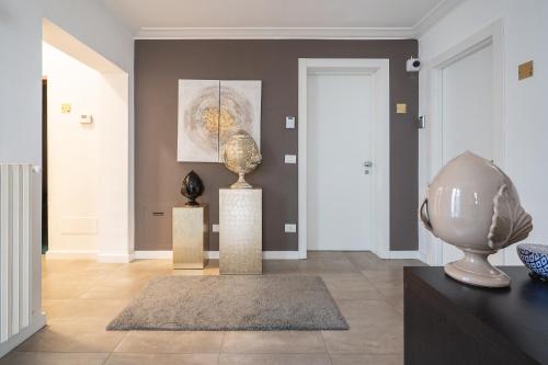 a living room with a vase on a pedestal and a painting at Fourooms - Bari Sparano in Bari