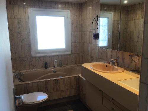 uma casa de banho com uma banheira e um lavatório e uma banheira em 2 pièces rez-de-jardin dans maison avec piscine em Villeneuve-Loubet
