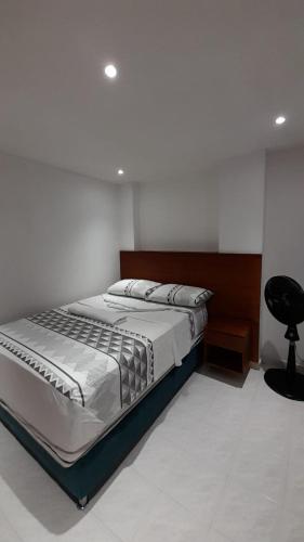 a bedroom with a bed and a black chair at Aparta suit Rodadero in Gaira