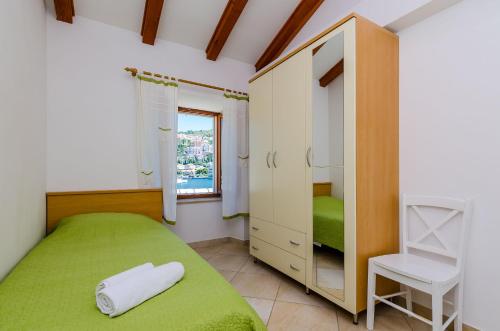 Orka Apartments في دوبروفنيك: غرفة نوم بسرير اخضر وكرسي