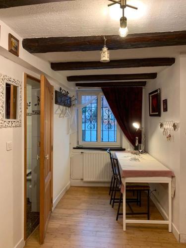 une salle à manger avec une table et des chaises et une fenêtre dans l'établissement La Casetta en ALSACE, à Schiltigheim