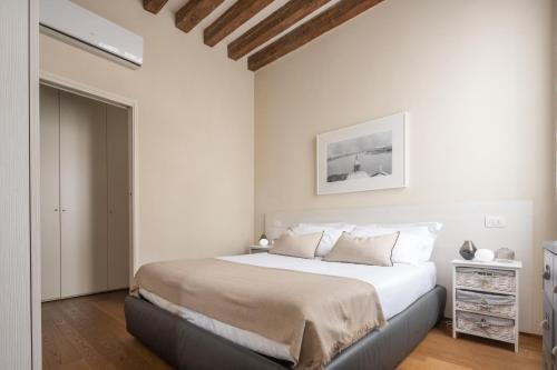 a bedroom with a large bed with white walls at Santa Fosca Design Apartment R&R in Venice