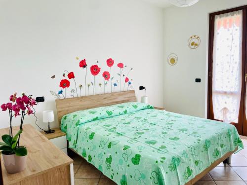 1 dormitorio con 1 cama y flores en la pared en Il Fienile di Manerba, en Manerba del Garda