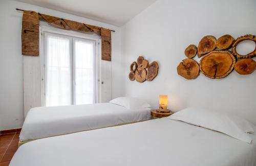 a white bedroom with two beds and a window at Monte do Giestal - Casas de Campo & Spa in Abela