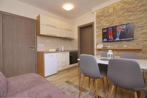 兹拉蒂博尔Natali Apartman的房间里有一张桌子和几把椅子的厨房