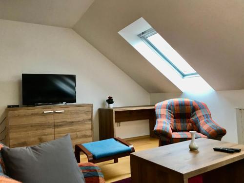 a living room with a tv and a couch and chairs at Apartmány Strážnice in Strážnice