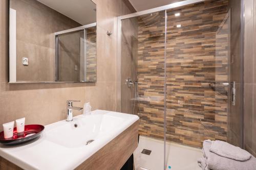 a bathroom with a sink and a glass shower at Fourooms - Bari Sparano in Bari