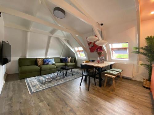 a living room with a green couch and a table at Casa Coral - a hidden gem for families in Groningen