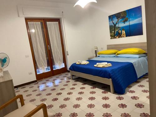 a bedroom with a bed with blue sheets and yellow pillows at Sorrento Dolce Casa in Sorrento