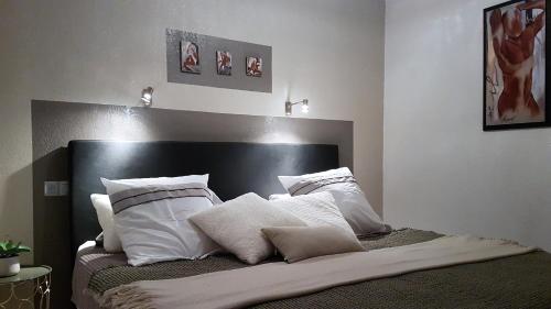 une chambre avec un lit avec des oreillers blancs dans l'établissement Villa Village Naturiste Farel, au Cap d'Agde