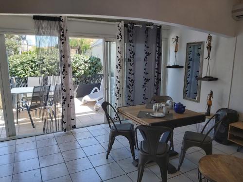 une salle à manger avec une table et des chaises et un balcon dans l'établissement Villa Village Naturiste Farel, au Cap d'Agde