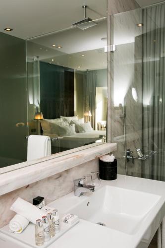 a bathroom with a sink and a large mirror at Pousada de Lisboa - Small Luxury Hotels Of The World in Lisbon