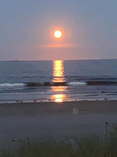 a sunset on the beach with the sun setting at Patras Grand Beach Motel in Old Orchard Beach