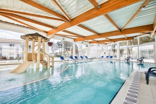 - une piscine avec toboggan dans un bâtiment dans l'établissement Vent d'Eden Park Hôtel, à Saint-Hilaire-de-Riez