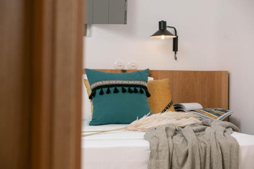 a bed with a bunch of pillows on it at Alio Naxos Luxury Suites in Agios Georgios