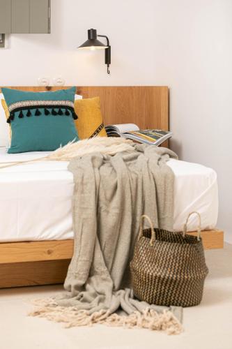 a bedroom with a bed with a blanket and a basket at Alio Naxos Luxury Suites in Agios Georgios