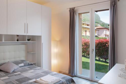 a bedroom with a bed and a sliding glass door at Appartamento Zerboni C2 in Lenno