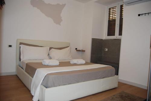 a bedroom with a bed with two towels on it at Suite Dreams in Agrigento