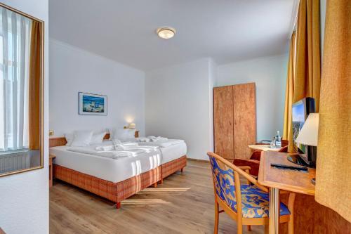 a hotel room with a bed and a desk at Haus Seeblick Hotel Garni & Ferienwohnungen in Zinnowitz
