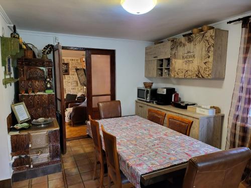 a dining room with a table and a kitchen at Vila Magnolia in Curtea de Argeş