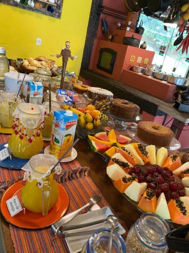 una mesa con fruta y otros alimentos. en Pousada Brisa do Vale, en Ipiabas