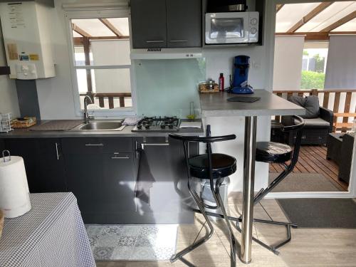 uma cozinha com um balcão, um lavatório e um fogão em Mobilhome TOUT CONFORT em Mimizan