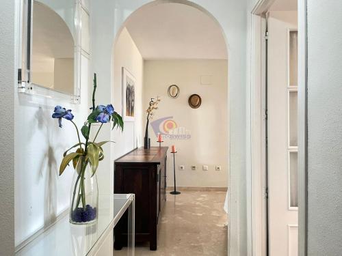 un couloir avec un vase de fleurs sur une table dans l'établissement Tropical penthouse, à Rincón de la Victoria