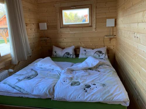 a bed in a room with a wooden wall at Ferienhaus Tollensesee in Groß Nemerow