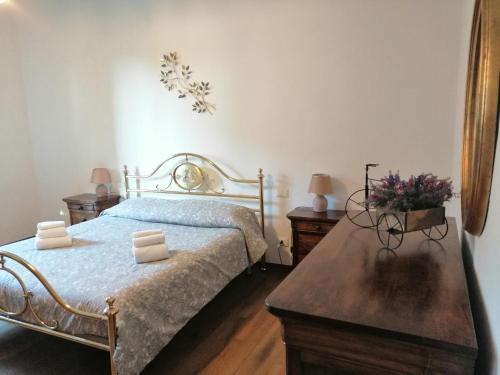 a bedroom with a bed and a table with flowers on it at La Dimora degli Olivi in Torrita di Siena