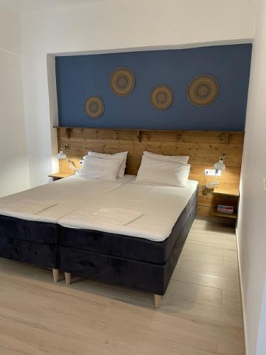 Gennadi Beach Apartments في غينادي: غرفة نوم مع سرير كبير مع اللوح الأمامي الأزرق