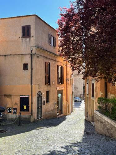 een lege straat met een gebouw en een boom bij CoreHome in Albano Laziale
