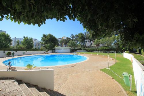 a large swimming pool in a park with a tree at Praia_da_Rocha_Vista_Mar/Ocean_View in Portimão