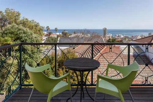 a table and chairs on a balcony with a view at Maartens Guesthouse in Cape Town