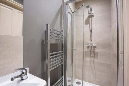 a shower with a glass door next to a sink and a toilet at Patrick's Pool- 4 Bedroom,4 Bathroom, Most Central Luxury Townhouse! in York