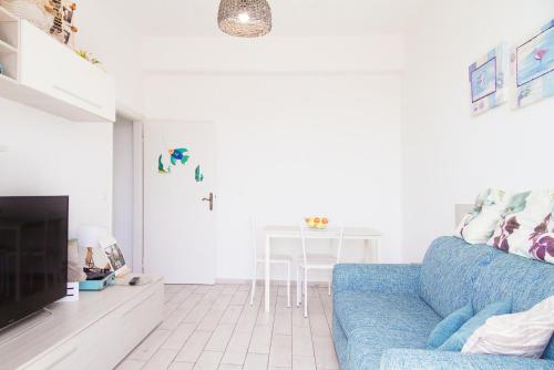 a living room with a blue couch and a table at Carola's Home - Goelba in Portoferraio