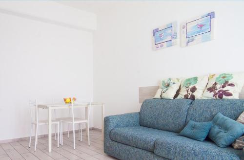 a living room with a blue couch and a table at Carola's Home - Goelba in Portoferraio