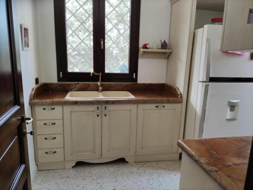 eine Küche mit einem Waschbecken und einem Fenster in der Unterkunft Villa Celea in Novoli