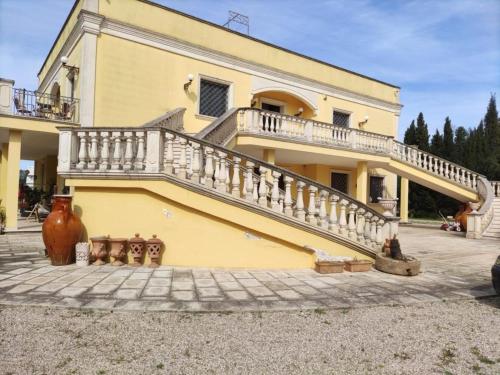 ein gelbes Haus mit einer Seitentreppe in der Unterkunft Villa Celea in Novoli