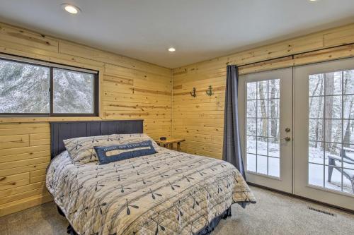 a bedroom with wooden walls and a bed and windows at Deerskin Lodge with Boat Dock and Fire Pit! in Eagle River