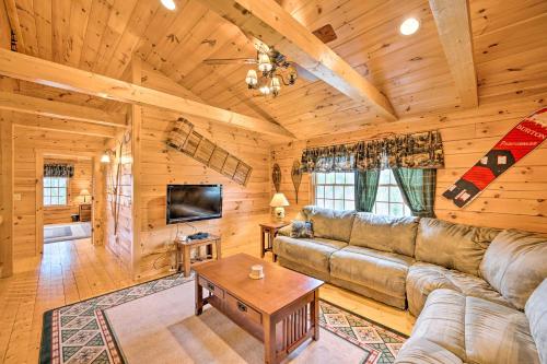a living room with a couch and a tv in a cabin at 9 Mi to Bretton Woods Carroll Log Cabin with Deck in Carroll