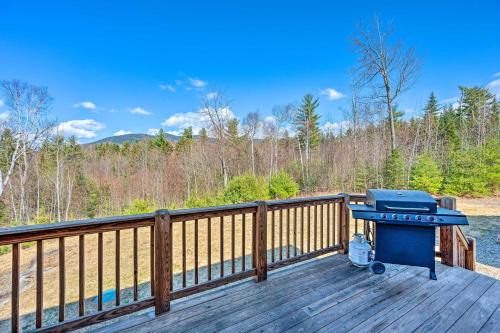 a grill on a deck with a view of the woods at 9 Mi to Bretton Woods Carroll Log Cabin with Deck in Carroll