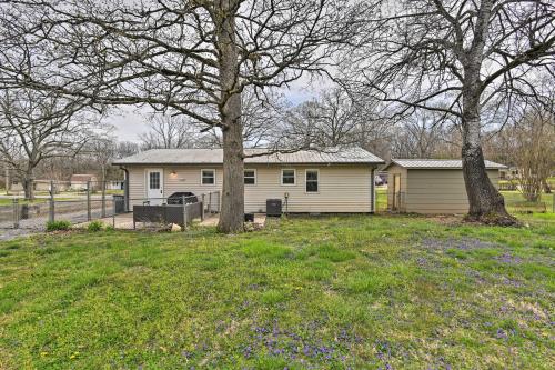 a house in a yard with two trees and flowers at Cozy Murfreesboro Home with Furnished Patio! in Murfreesboro