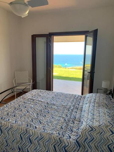 a bedroom with a bed with a view of the ocean at Villino Caddu in San Teodoro